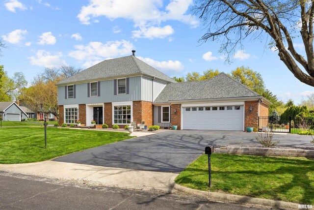 colonial home with a garage and a front yard