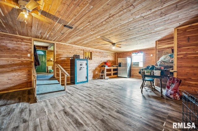 unfurnished living room featuring wood-type flooring, wood ceiling, wooden walls, and ceiling fan