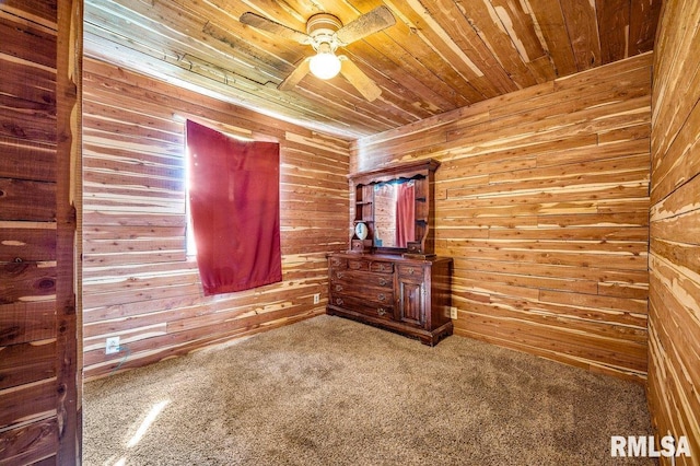 interior space with wood walls, wood ceiling, ceiling fan, and carpet floors