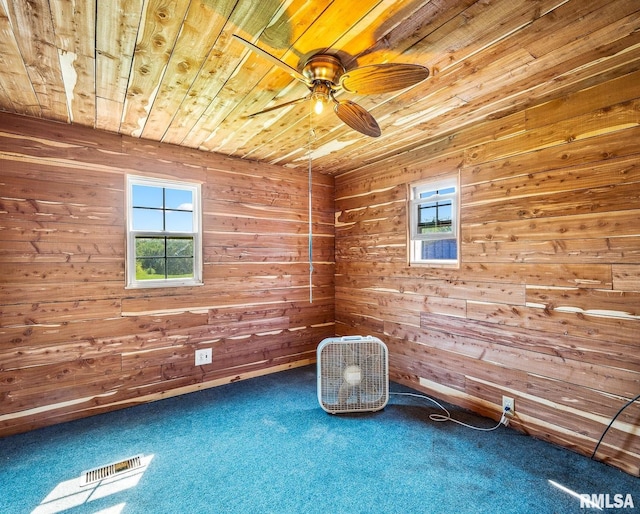 unfurnished room with wood ceiling, carpet flooring, ceiling fan, and wood walls