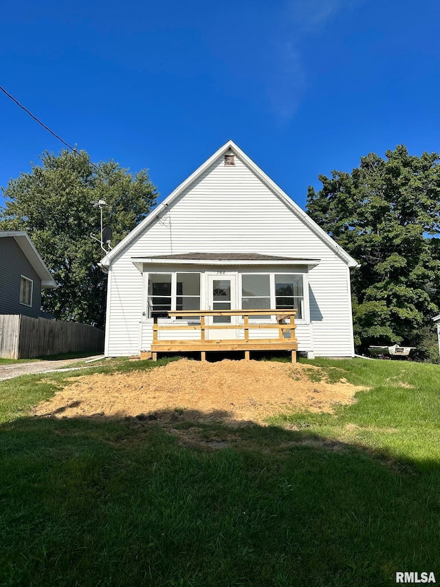 view of front of property with a deck and a front lawn