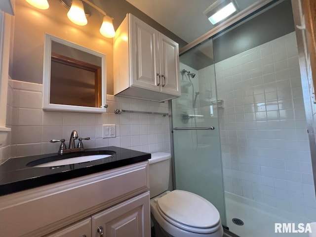 bathroom featuring tile walls, backsplash, vanity, a tile shower, and toilet