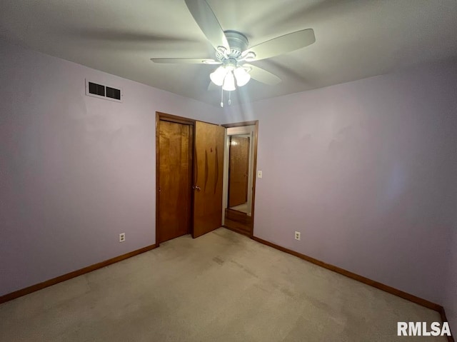 unfurnished bedroom featuring ceiling fan, light colored carpet, and a closet