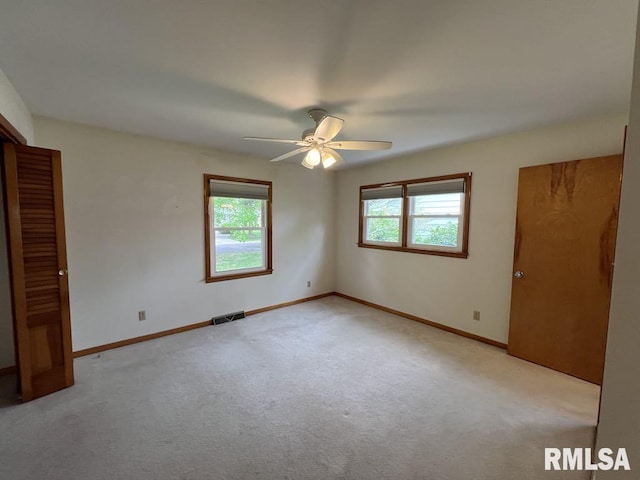 849 E Franklin St, Macomb, IL 61455 - unfurnished bedroom with light colored carpet, baseboards, and ceiling fan