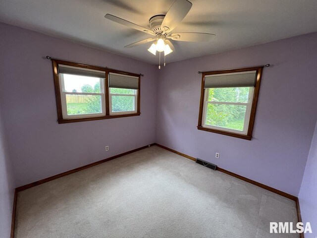 849 E Franklin St, Macomb, IL 61455 - spare room featuring light colored carpet, a ceiling fan, and baseboards