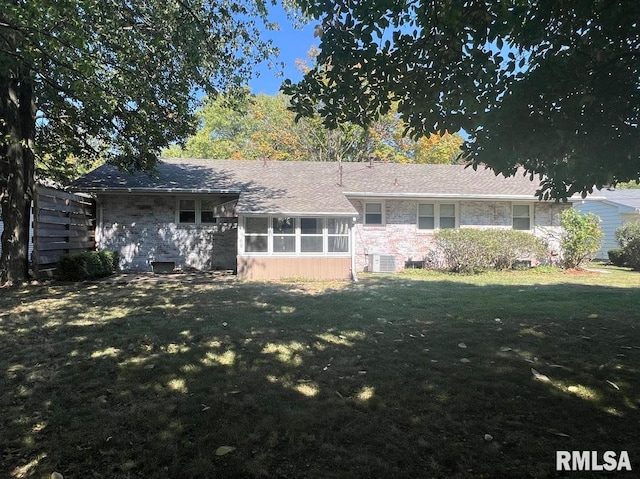 view of front of home with central air condition unit and a front yard