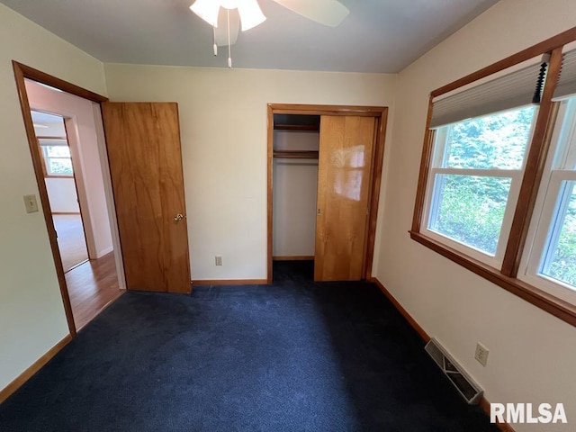 849 E Franklin St, Macomb, IL 61455 - unfurnished bedroom featuring dark carpet, baseboards, a closet, and a ceiling fan