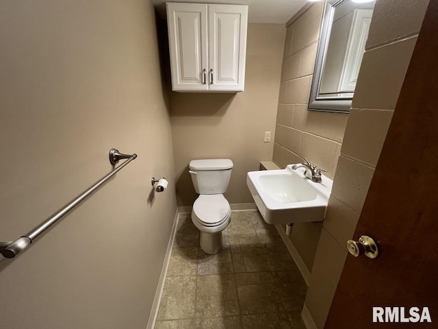 849 E Franklin St, Macomb, IL 61455 - bathroom featuring a sink, toilet, baseboards, and backsplash