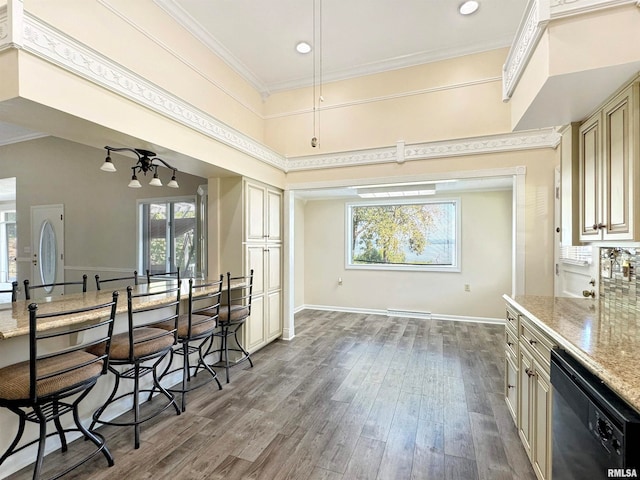 kitchen featuring cream cabinets, light stone countertops, wood-type flooring, black dishwasher, and ceiling fan