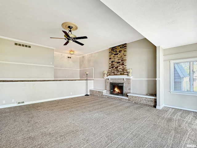 unfurnished living room featuring ornamental molding, a brick fireplace, ceiling fan, carpet flooring, and brick wall