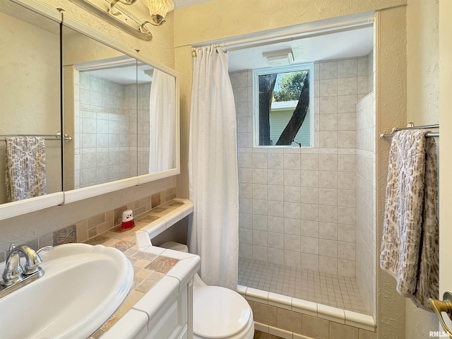 bathroom featuring a shower with shower curtain, toilet, and vanity