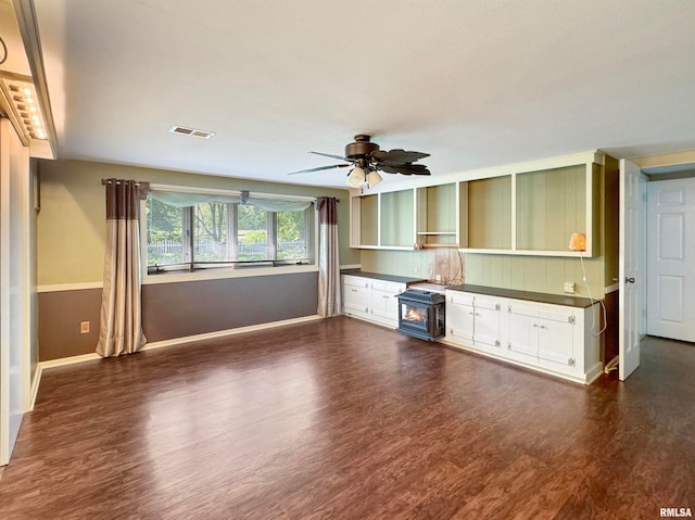 unfurnished living room featuring dark wood-type flooring and ceiling fan