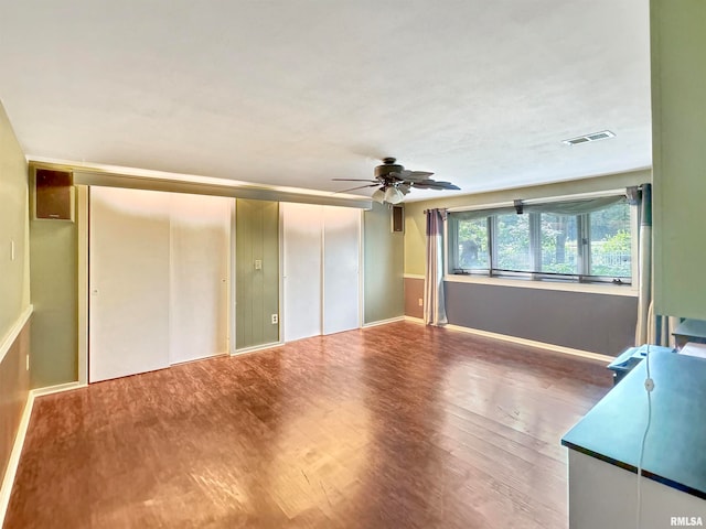 unfurnished living room with ceiling fan and wood-type flooring