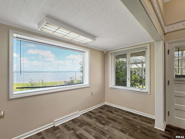 empty room featuring a wealth of natural light, crown molding, and dark hardwood / wood-style flooring