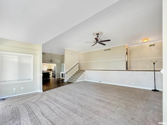 unfurnished living room with ornamental molding, a fireplace, ceiling fan, and carpet