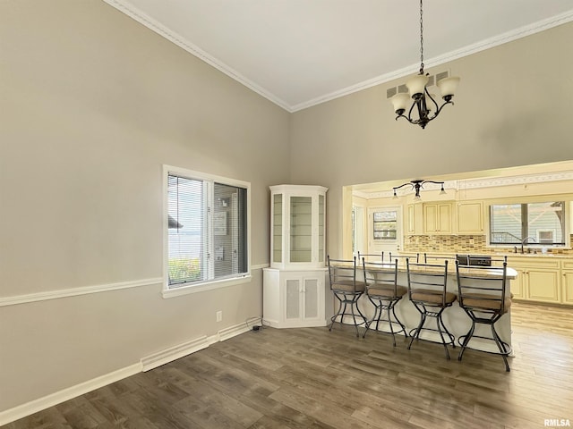 kitchen featuring a wealth of natural light, an inviting chandelier, backsplash, and dark hardwood / wood-style flooring