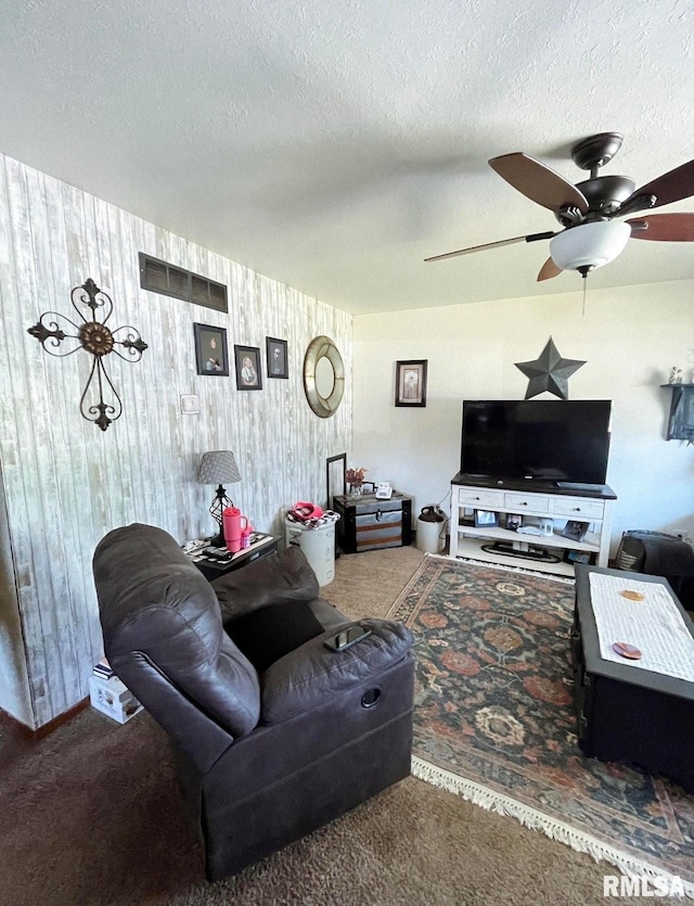 carpeted living room featuring a textured ceiling and ceiling fan