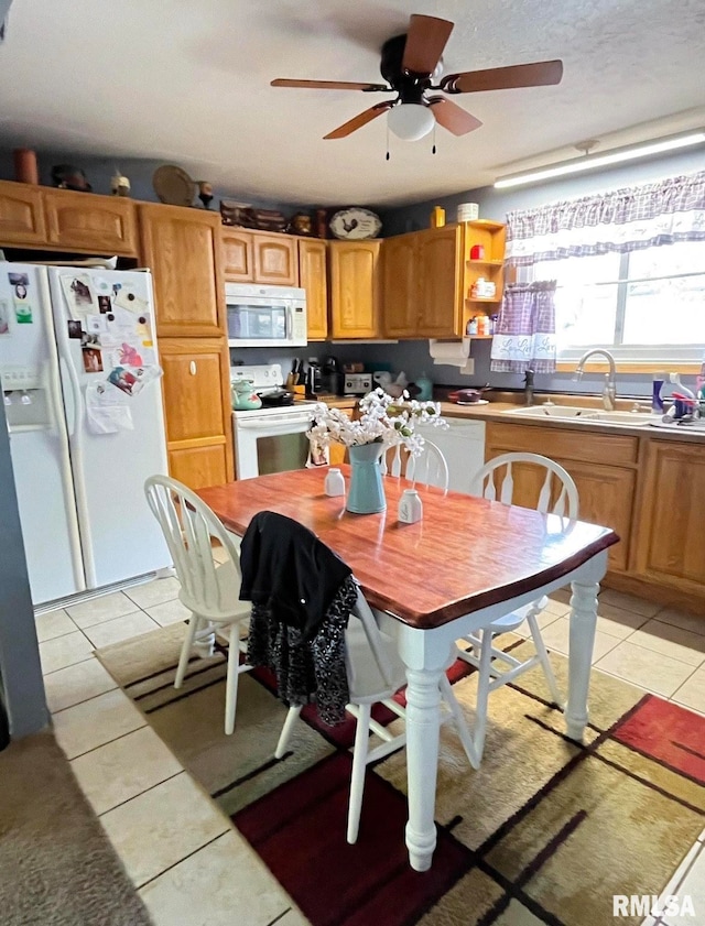 kitchen featuring ceiling fan, sink, light tile patterned floors, and white appliances