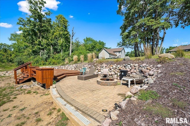 exterior space featuring an outdoor fire pit and a deck