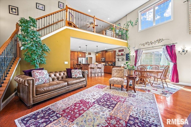 living room with a high ceiling and hardwood / wood-style flooring