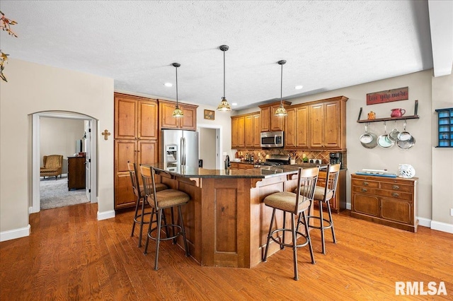 kitchen featuring a center island, a breakfast bar, stainless steel appliances, and light hardwood / wood-style floors