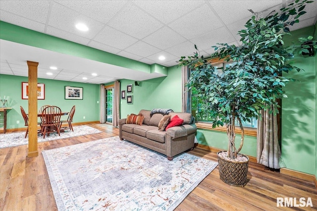 living room with hardwood / wood-style floors and a paneled ceiling