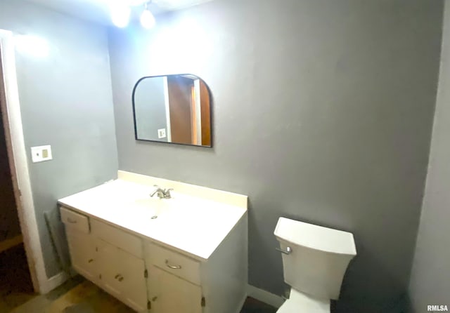 half bath featuring toilet and vanity