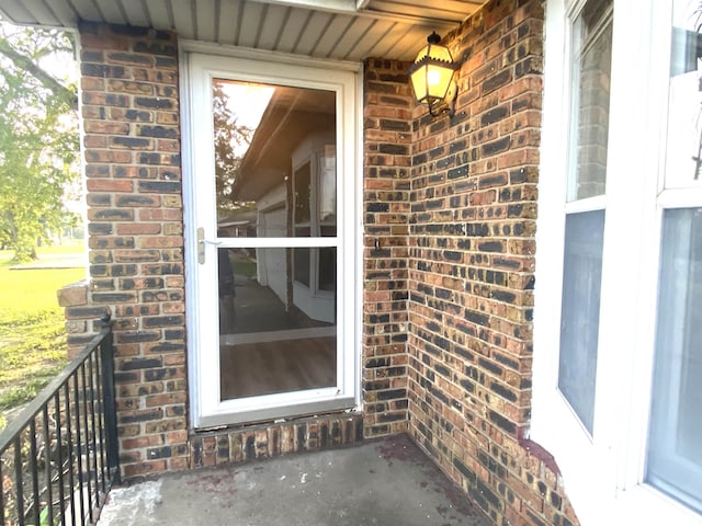 view of exterior entry featuring brick siding