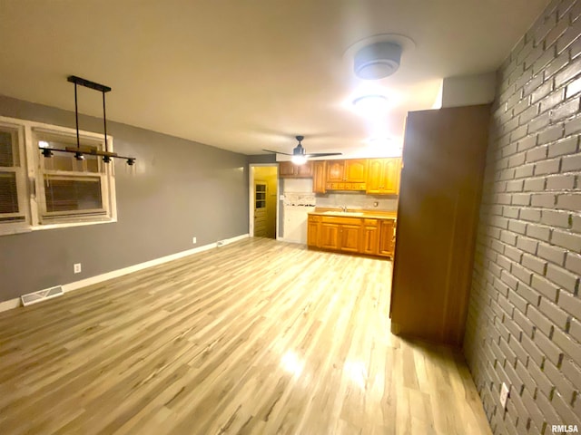 kitchen with a ceiling fan, baseboards, visible vents, light countertops, and light wood-style floors