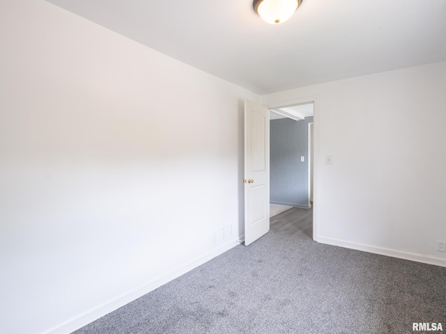 carpeted spare room featuring visible vents and baseboards