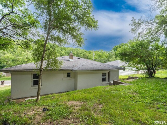 back of property featuring a lawn