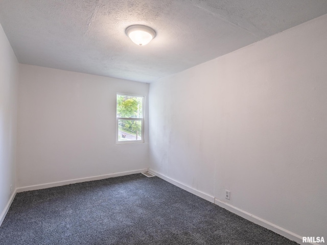 unfurnished room with a textured ceiling, baseboards, and dark colored carpet