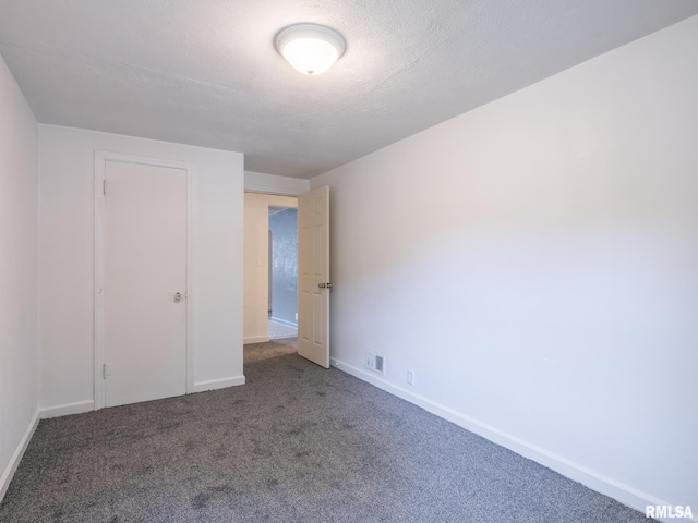 unfurnished room featuring baseboards, visible vents, carpet floors, and a textured ceiling