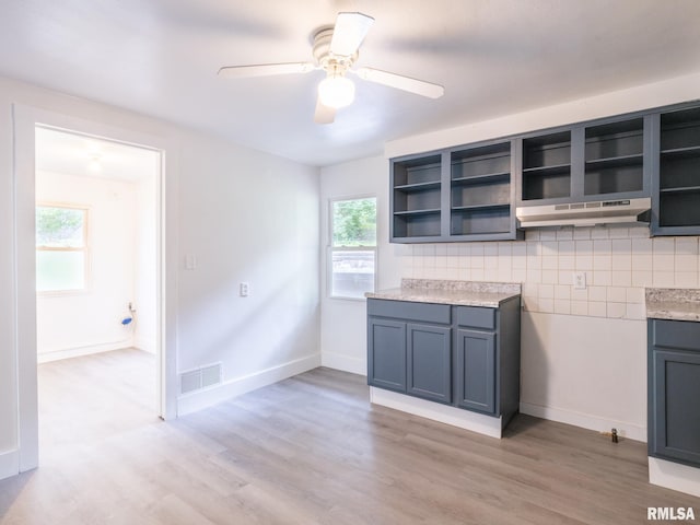 kitchen featuring under cabinet range hood, visible vents, light wood-style flooring, and open shelves