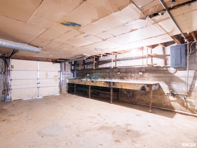 garage with concrete block wall and electric panel
