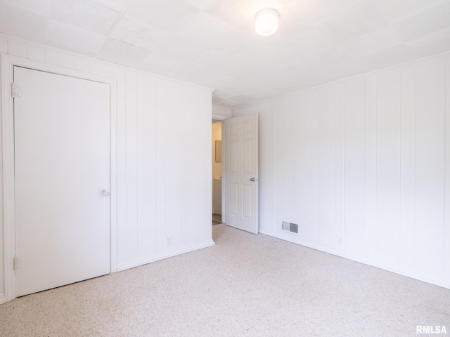 unfurnished room featuring visible vents