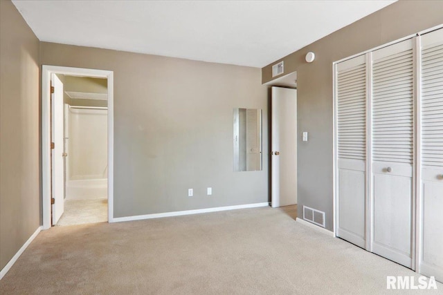 unfurnished bedroom with light carpet, a closet, and connected bathroom