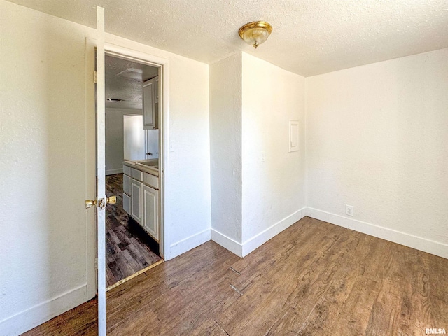 empty room featuring dark wood-type flooring and a textured ceiling