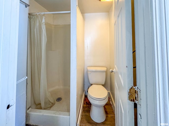 bathroom with toilet, curtained shower, and hardwood / wood-style floors