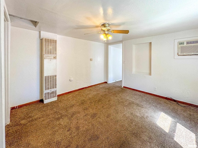 spare room featuring a wall unit AC, a textured ceiling, carpet, and ceiling fan