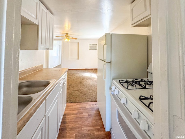 kitchen with sink, white range with gas cooktop, white cabinetry, light hardwood / wood-style floors, and ceiling fan