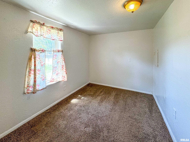 carpeted empty room featuring a textured ceiling