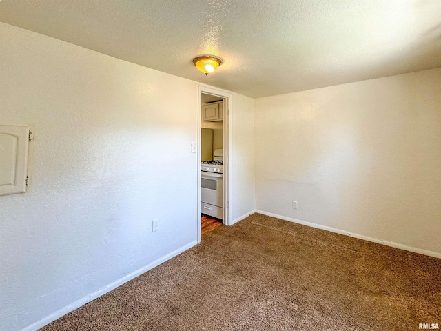 empty room with a textured ceiling and dark carpet