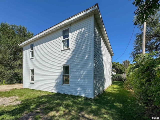 view of side of home with a yard