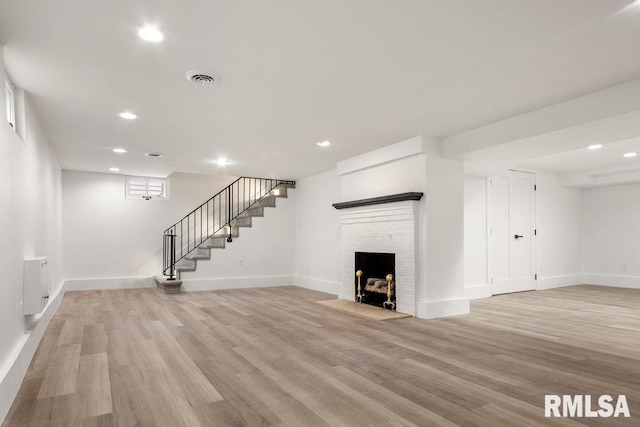 unfurnished living room with a fireplace and light wood-type flooring