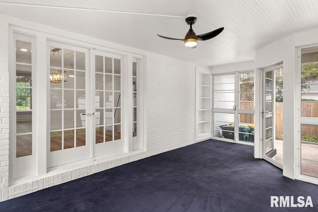 unfurnished sunroom featuring ceiling fan and french doors