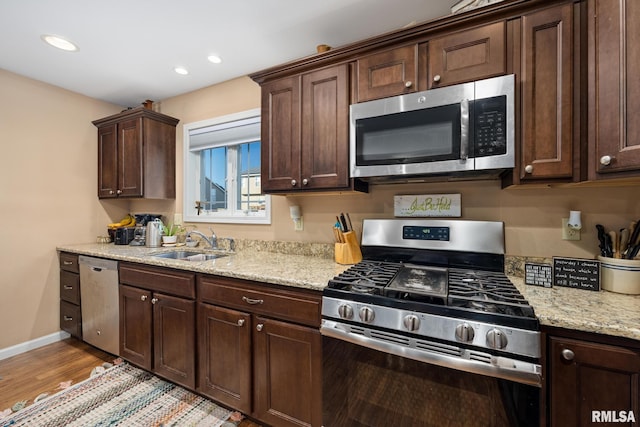 kitchen with light hardwood / wood-style floors, appliances with stainless steel finishes, sink, and dark brown cabinets