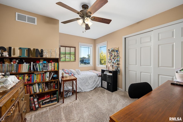 bedroom with a closet, light colored carpet, and ceiling fan