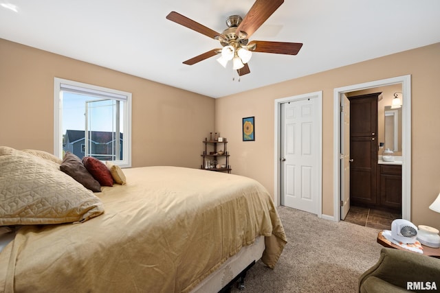 bedroom with ceiling fan, carpet flooring, and ensuite bathroom