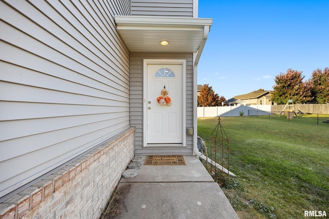 view of exterior entry with a lawn